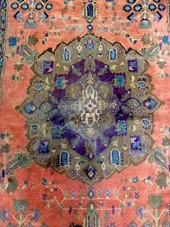 Persian type red  ground carpet with a purple border the centre with repeating foliate forms 160cm x 220cm