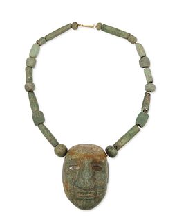 A carved greenstone mask necklace