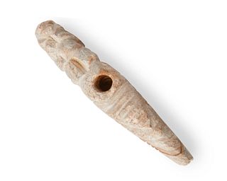 A carved stone effigy pipe