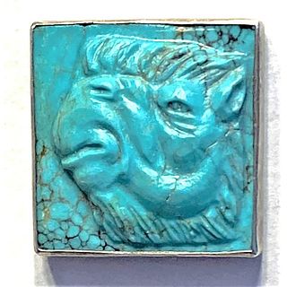 A HEVILY CARVED TURQUOISE STONE OF A CAMEL BUTTON