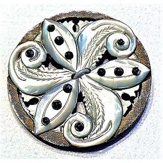 A DIVISION ONE HEVILY CARVED AND PIERCED PEARL BUTTON