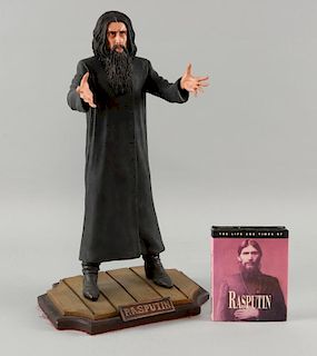 Rasputin figure of Sir Christopher Lee (14 inches h) & a small book.Provenance: From the Estate of Sir Christopher Lee