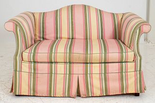 Georgian Style camelback scroll arm slip-covered love seat, the shaped back above a cushioned seat, with skirted slipcover in pink and green awning st