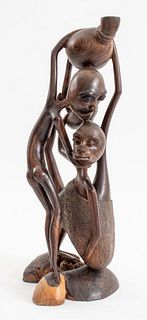 African wooden sculpture depicting three interlacing human figures, signed "Mirambo" to underside. 15.75" H x 7.5" W x 5.75" D.