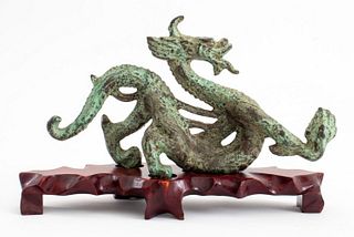 Chinese dragon bronze sculpture with verdigris patina raised on wooden pedestal, apparently unsigned. Sculpture only: 5" H x 9.25" W x 2.5" D.