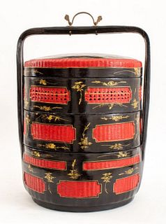 Chinese lacquered stacking basket in black and red, with caned steam escapes and gilded details. 20" H x 16" W x 14" D.