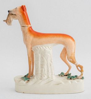 Staffordshire ceramic tall greyhound with rabbit on a hite firled with green glass clusters. 11" H x 9" L x 3.5" W.