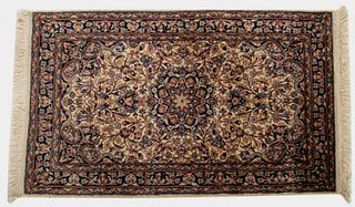 Persian Sarouk carpet with hand-woven repeating floral design encircling a central rosette medallion. 4' 6" H x 2' 7" W.