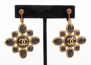 Pair of Chanel Runway earring clips in gold-tone metal with black and gold glitter enamel cabochons in geometric shapes encircling signature double-C 