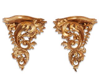 A pair of carved giltwood wall shelves