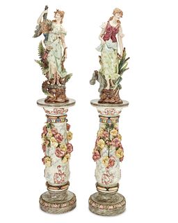 A pair of Continental majolica figures with pedestals