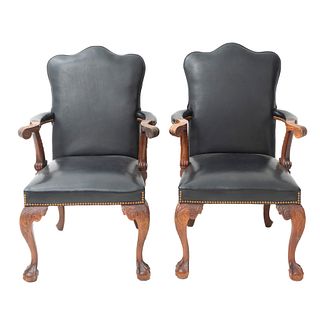 PAR DE SILLONES. S XX. Elaborados en madera. Con tapicería en color negro. Respaldos cerrados, asiento acojinado y soportes acojinados.