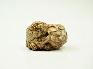 A Chinese pale grey-brown jade model of a Buddhist lion