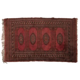 TAPETE. ORIGEN PERSA, SXX. Estilo BOKHARA. Elaborado en fibras de lana y algodón. Decorado con motivos geométricos en tonos rojos.
