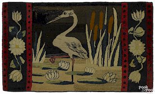 American hooked rug of a heron and cattails, early 20th c., with floral end borders, 51'' x 30''.
