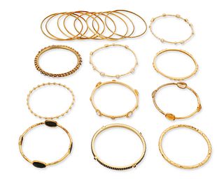 A group of gold-toned bangle bracelets