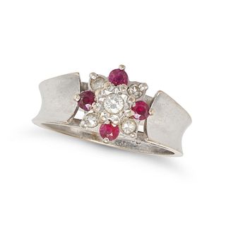 A DIAMOND AND RUBY FLOWER RING in 18ct white gold, set with a round brilliant cut diamond in a cl...