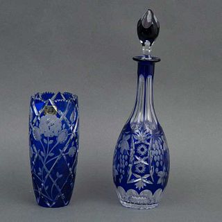 JUEGO DE FLORERO Y LICORERA CHECOSLOVAQUIA SIGLO XX Elaborado en cristal de Bohemia en color azul Decoración floral y faceta...