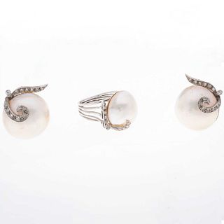 Anillo y par de aretes con tres medias perlas color blanco de 19 mm y 38 diamantes corte 8 x 8 en plata paladio. Talla: 8. Peso:...
