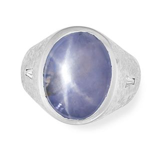 A STAR SAPPHIRE AND DIAMOND RING in 14ct white gold, the tapering textured band set with a caboch...
