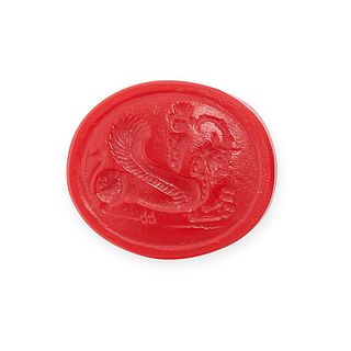 NO RESERVE - A RED GLASS INTAGLIO depicting a winged sphinx with antelope horns 2.0cm, 4.2g.