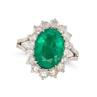 AN EMERALD AND DIAMOND CLUSTER RING in 18ct white gold, set with an oval cut emerald of 3.96 cara...