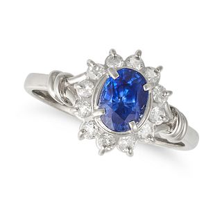 A SAPPHIRE AND DIAMOND CLUSTER RING in platinum, set to the centre with an oval cut sapphire of 1...