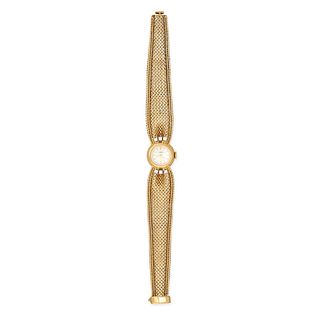 GUBELIN, A VINTAGE LADIES' WRISTWATCH in 18ct yellow gold, silver dial with gold baton hour marke...