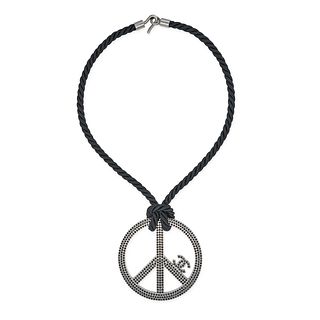CHANEL, A PEACE SIGN PENDANT NECKLACE, comprising a peace sign pendant with black rhinestone and ...
