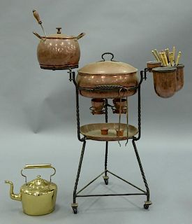 LA Monda copper fondue set on turned iron stand having center oval pot with iron hinges over burners, hand hammered. ht. 39in
