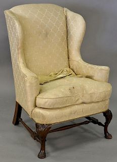 Custom mahogany Queen Anne style wing chair having shell carved knees and stretcher base.