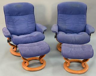 Pair of Contemporary swivel reclining chairs and ottomans.