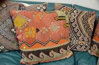 Eight throw pillows, three needlepoint and five Kilim flatweave rug pieces made into pillows.
