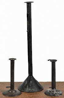 Two hogscraper candlesticks, together with a larger slide ejector stick, 19'' h.