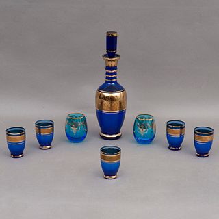 SET DE LICORERA SIGLO XX Elaborados en cristal color azul Detalles en esmalte dorado Consta de licorera, 5 vasos a juego y 2...