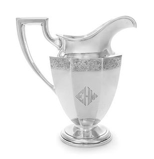 An American Silver Pitcher, Maker's Mark EB, having a paneled body with a foliate decorated band and an engraved monogram.
