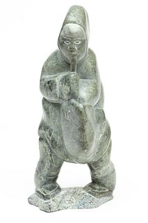 CANADIAN ESKIMO STONE CARVING OF A MAN BLOWING INTO A POUCH, Ca. 1957, H 15" W 7"