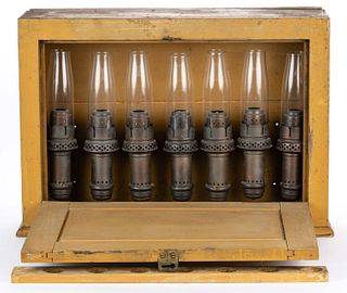 ROBERT MITCHELL CO. BRONZE CANDLE LAMPS IN WOODEN CABINET DISPLAY BOX, SEVEN-PIECE SET