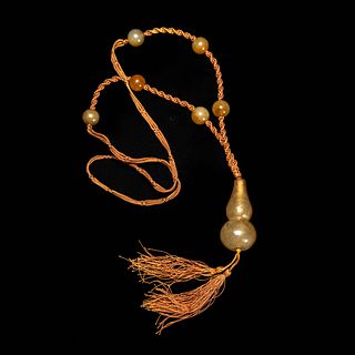 A RUSSET JADE DOUBLE-GOURD NECKLACE 
