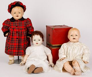 Three composition baby dolls with doll trunk