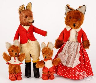 Four plush dressed foxes