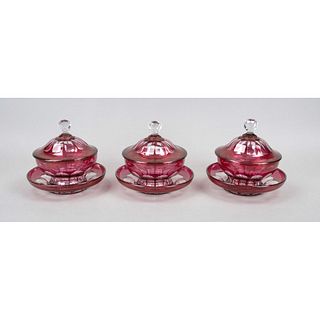 Three lidded jars with saucers