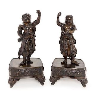 A Pair of Bronze Guardian-Form Candle Holders Height of each 12 3/4 inches.
