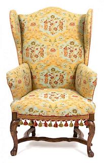 A Spanish Baroque Style Upholstered Wing Chair Height 47 x width 26 1/2 x depth 23 inches.