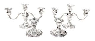 Two Pairs of Weighted Sterling Candlesticks, Various Makers, comprising a pair of three-light candlesticks and a pair of sing