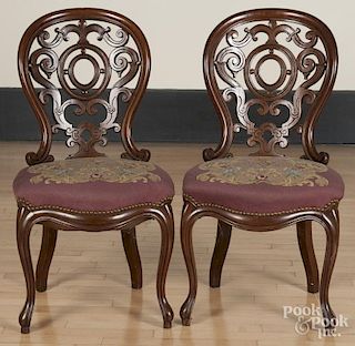 Pair of Victorian walnut side chairs with elaborately scalloped and pierced backs.