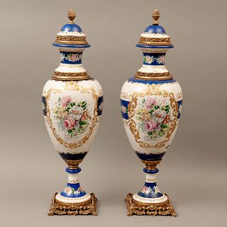 PAR DE TIBORES ITALIA SIGLO XX Elaborados en porcelana y metal dorado Decorado con elementos florales sobre fondo azul y esm...