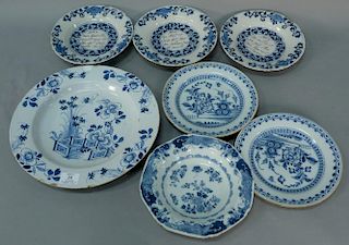 Seven Delft tin glazed pieces including plates, dish, and charger, three numbered 3, 4, 5. 
diameter 8 3/4 inches, 9 inches, 