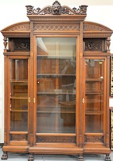 Walnut Victorian cabinet having large lion carved top gallery over floral carving over two shelves with dragon back panels an