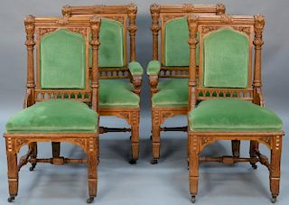 Set of four Victorian oak chairs including two armchairs and two side chairs having roll and foliate carved backs, in the man